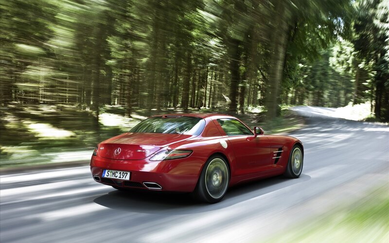 Red sports car on forest road