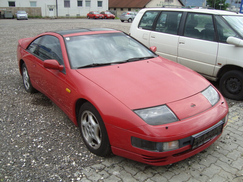 Red sports car on gravel lot