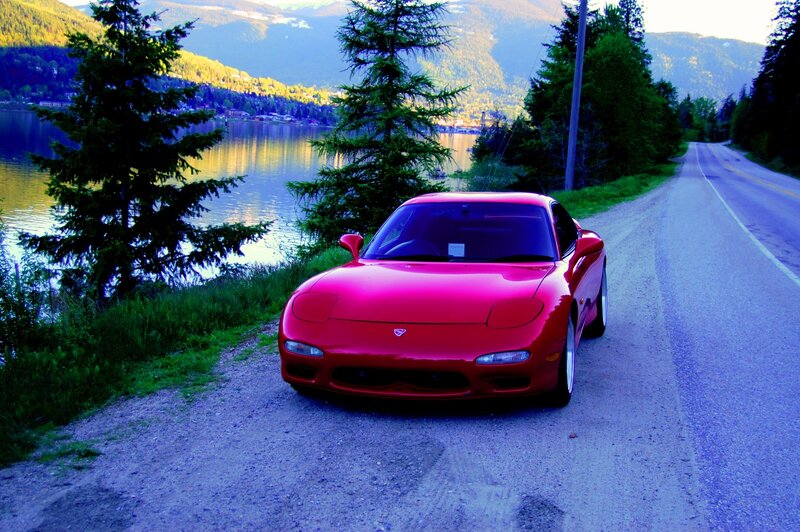 Red sports car on lakeside road