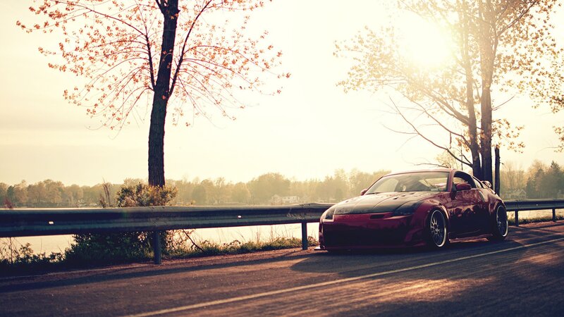 Red sports car on lakeside road