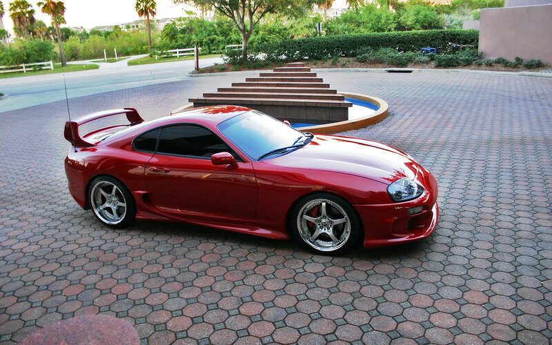 Red sports car on paved driveway