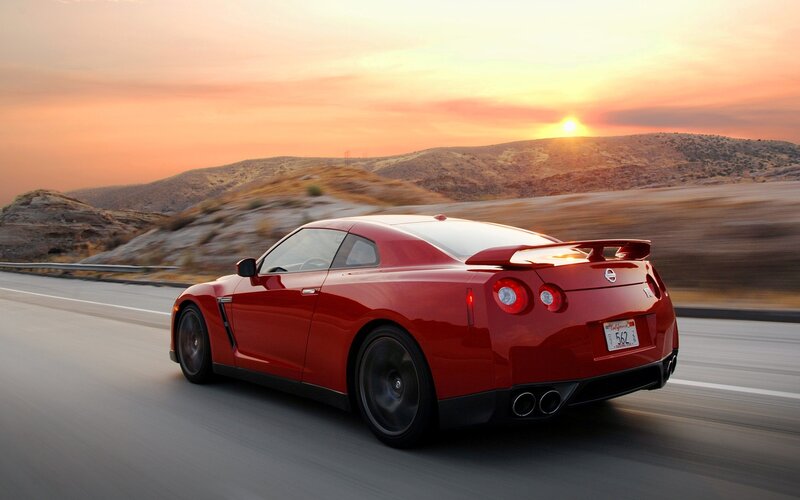 Red sports car on road at sunset