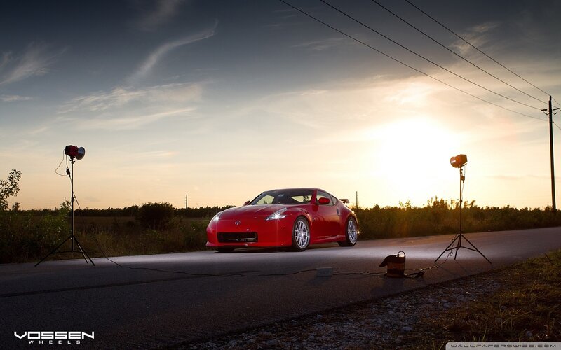Red sports car on road at sunset
