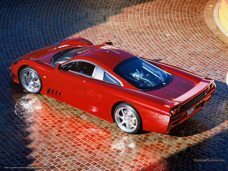 Red sports car on tiled pavement