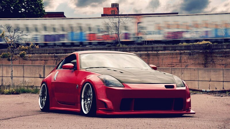 Red sports car on train tracks