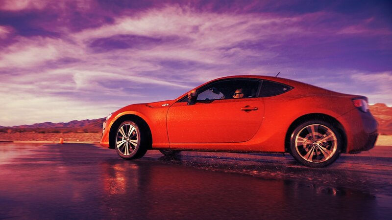 Red sports car on wet track
