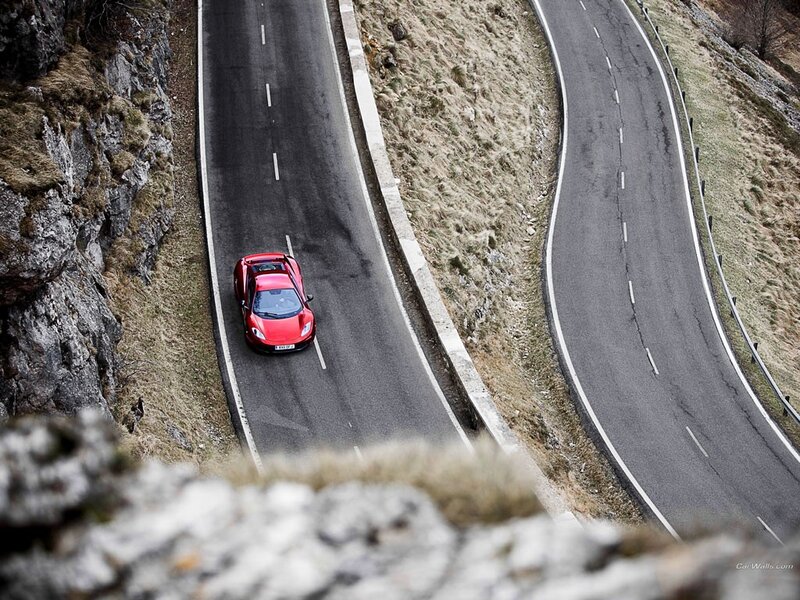 Red sports car on winding mountain road