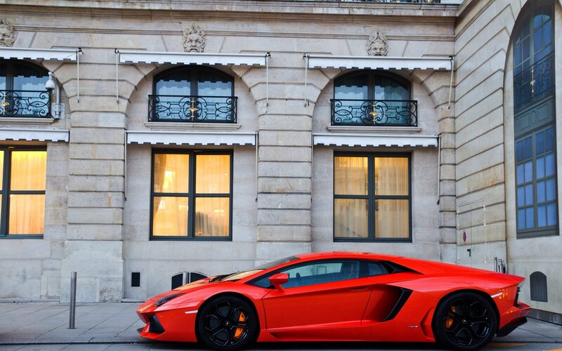Red sports car parked in front of building