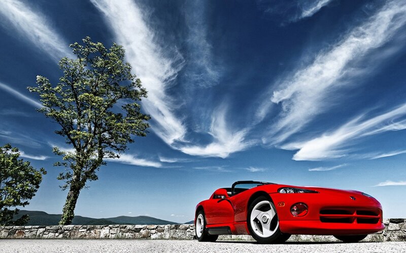 Red sports car under cloudy sky