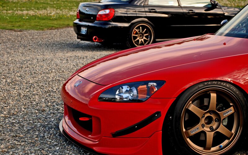 Red sports car with black sedan