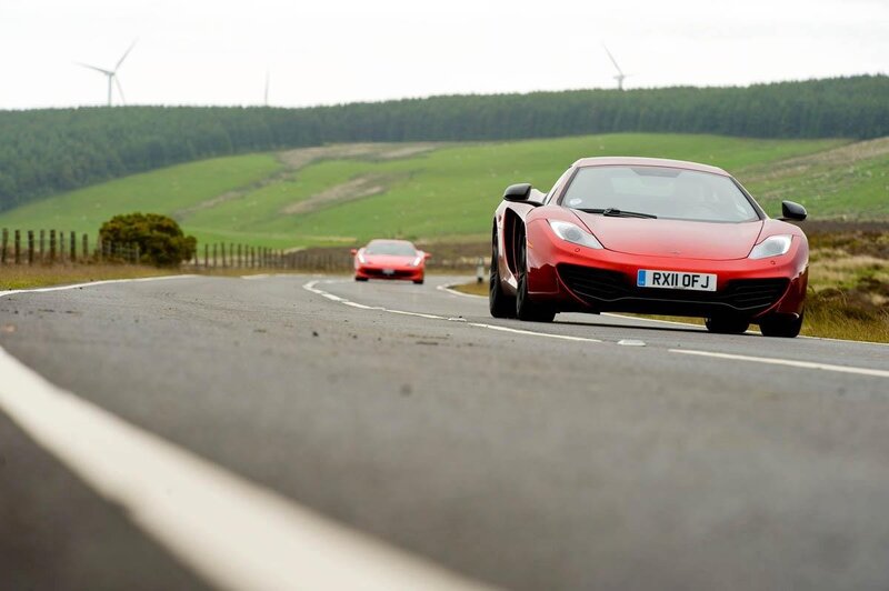 Red sports cars on a winding road