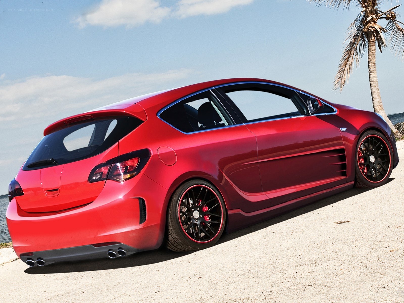 Red sports hatchback by the beach