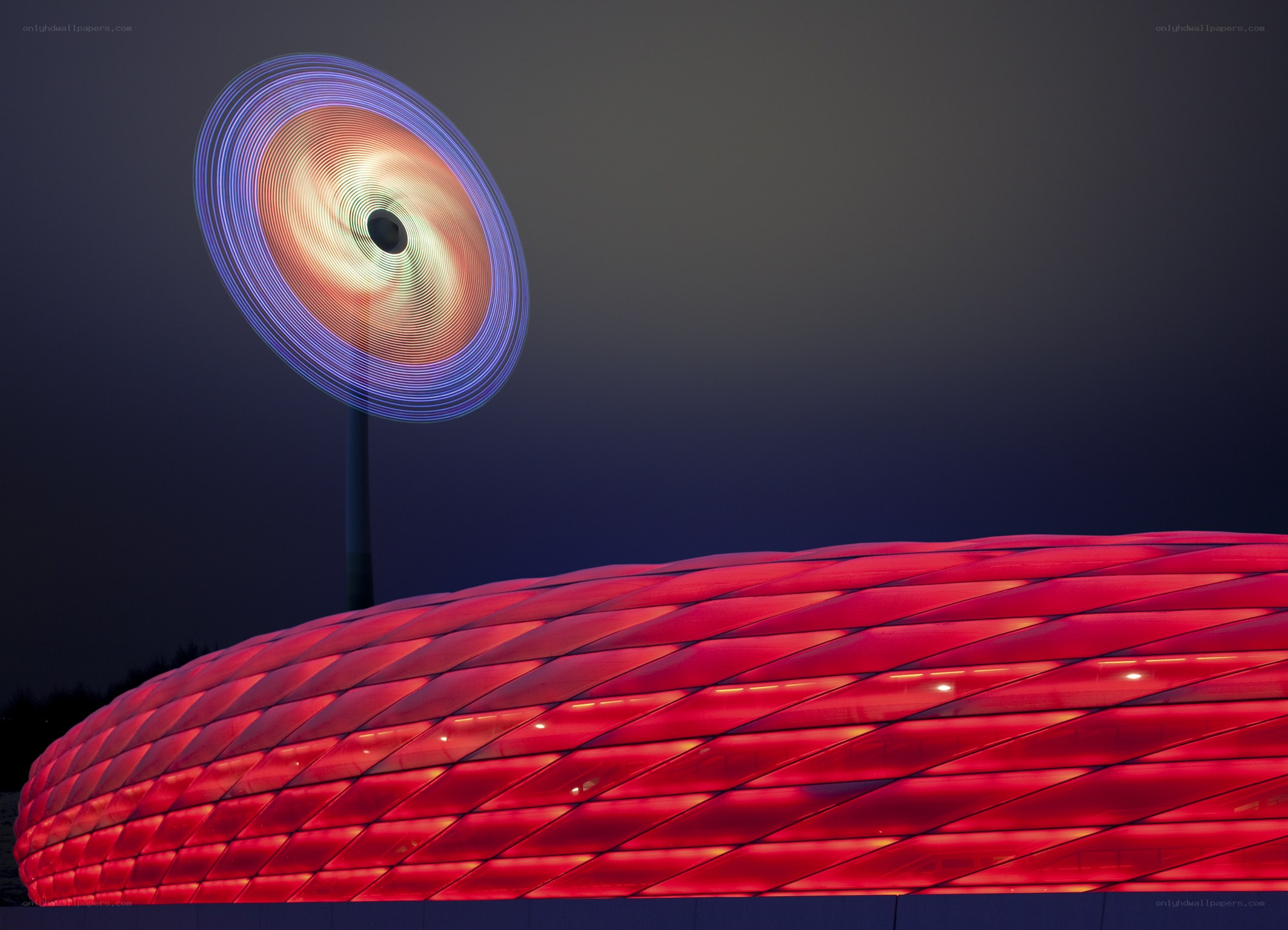 Red stadium at night with light art