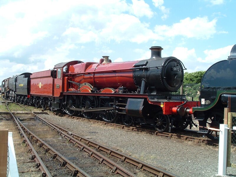 Red steam locomotive on tracks