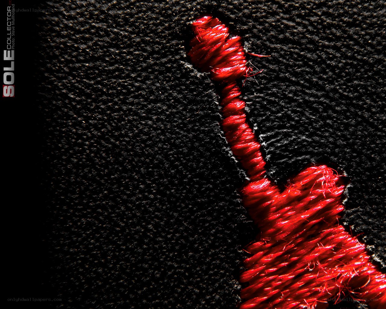 Red stitching on black fabric