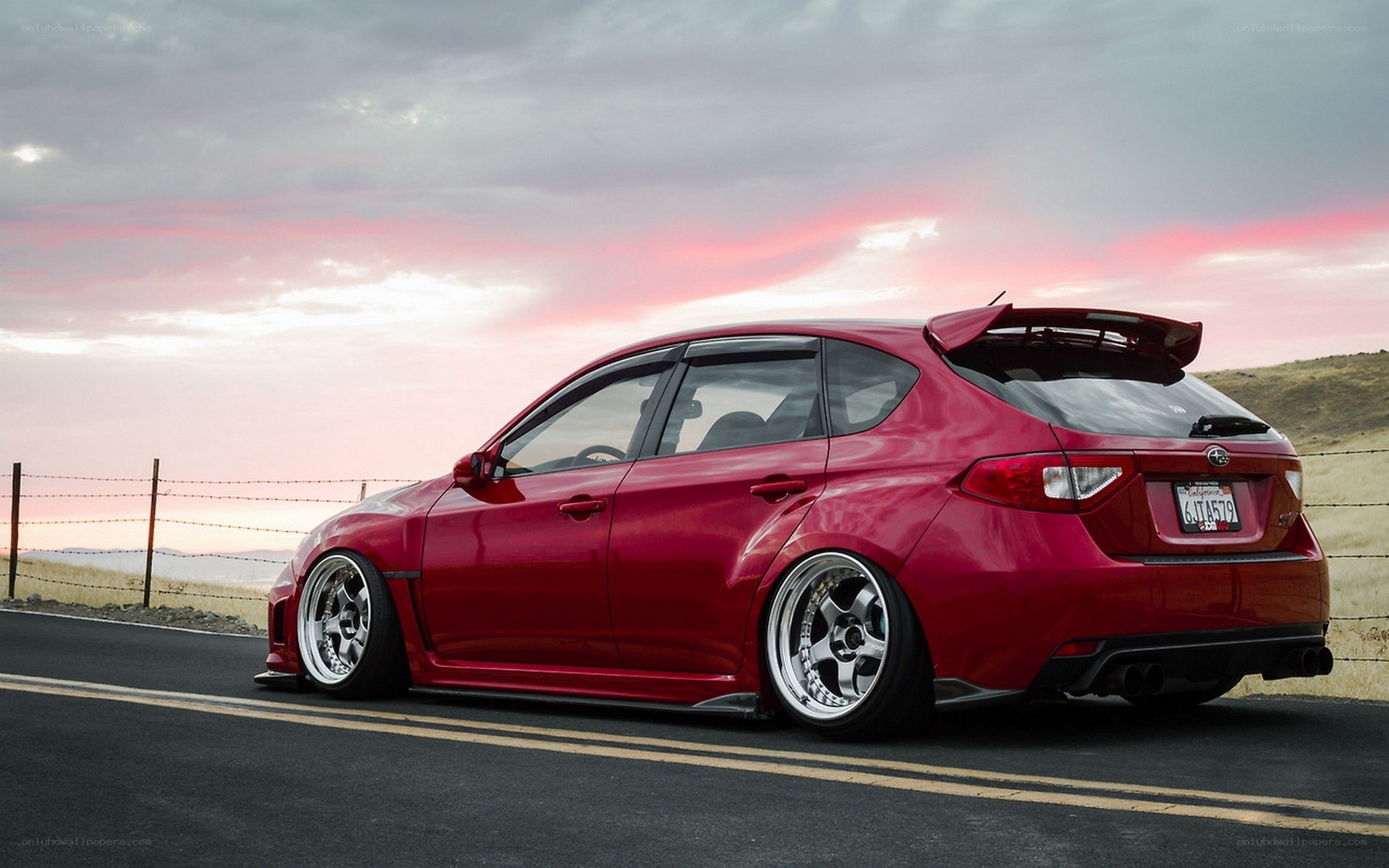 Red Subaru on a scenic road