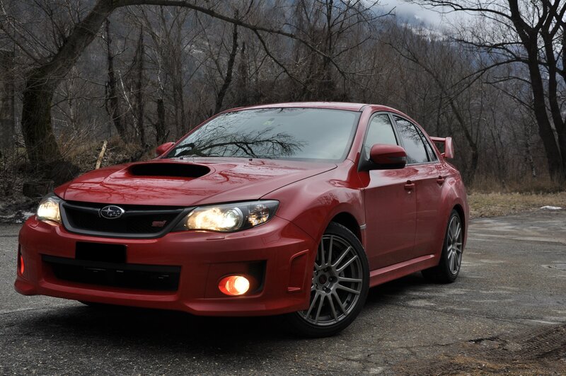 Red Subaru WRX parked in forest