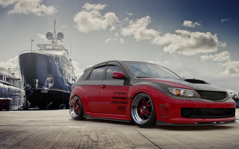 Red Subaru WRX STI with yacht