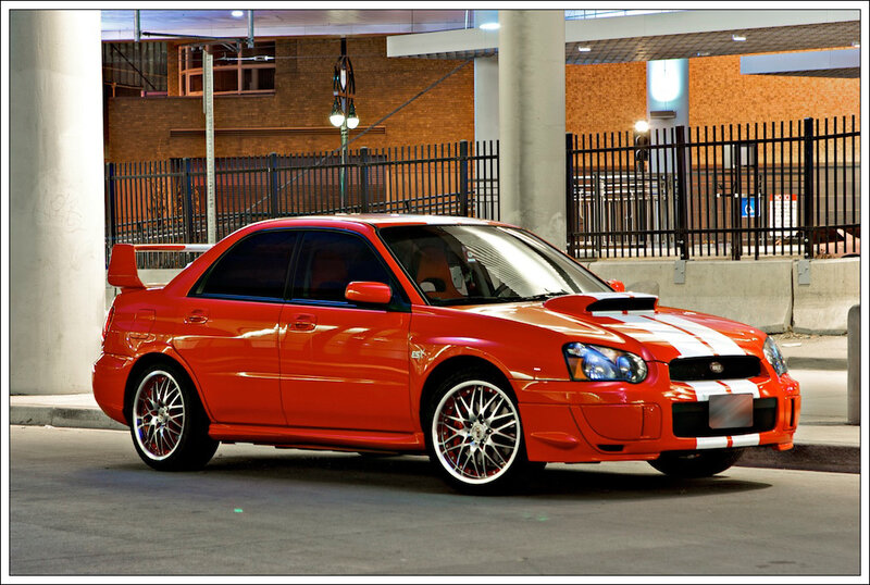 Red Subaru WRX with racing stripes
