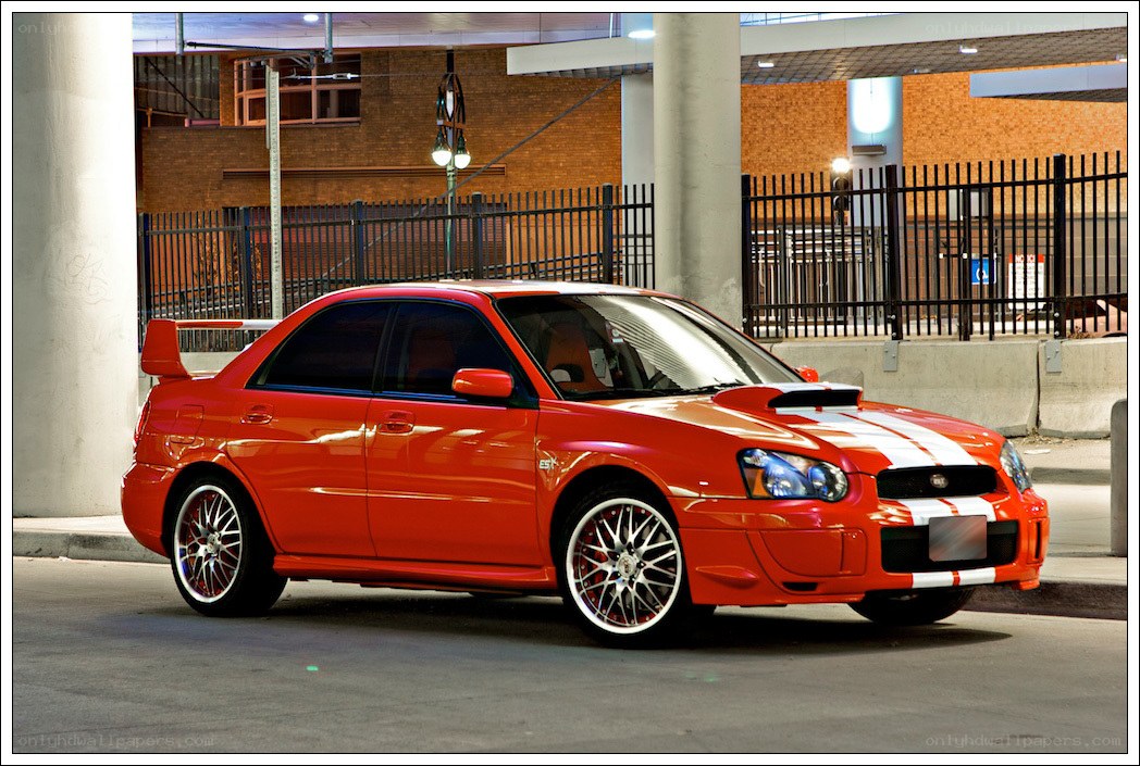 Red Subaru WRX with racing stripes