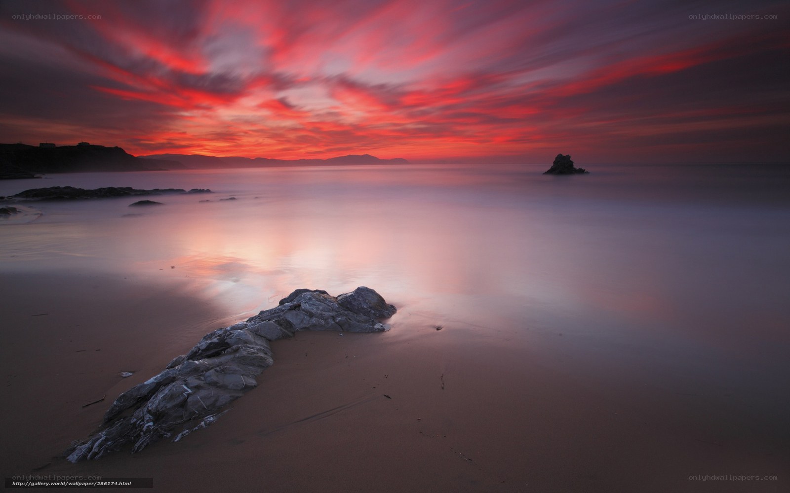 Red sunset over rocky beach