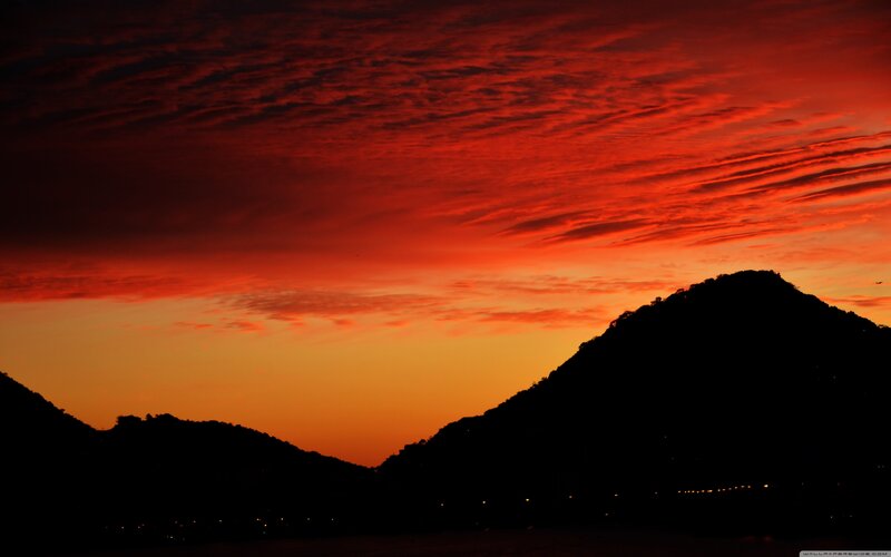 Red sunset over silhouetted mountains