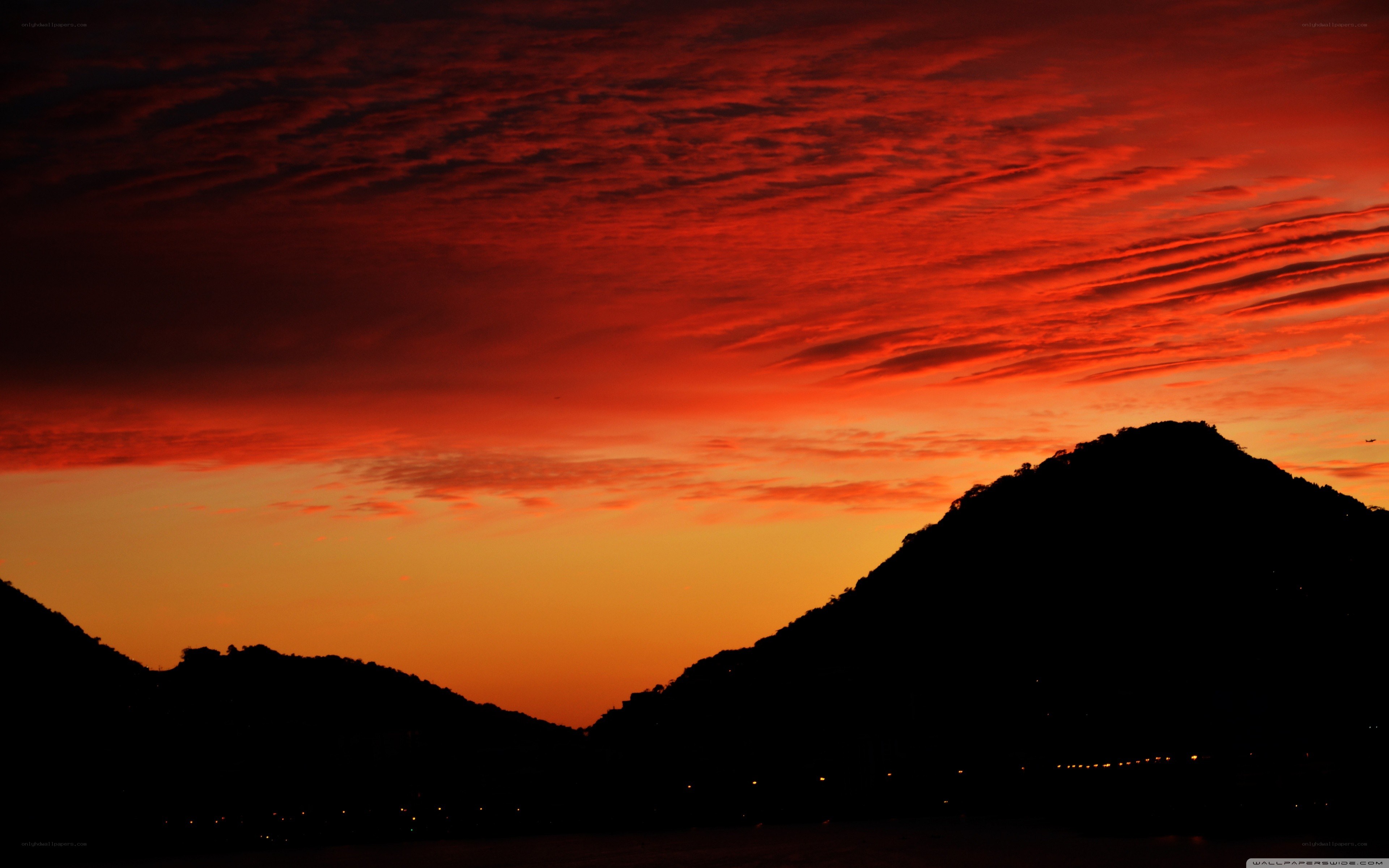 Red sunset over silhouetted mountains