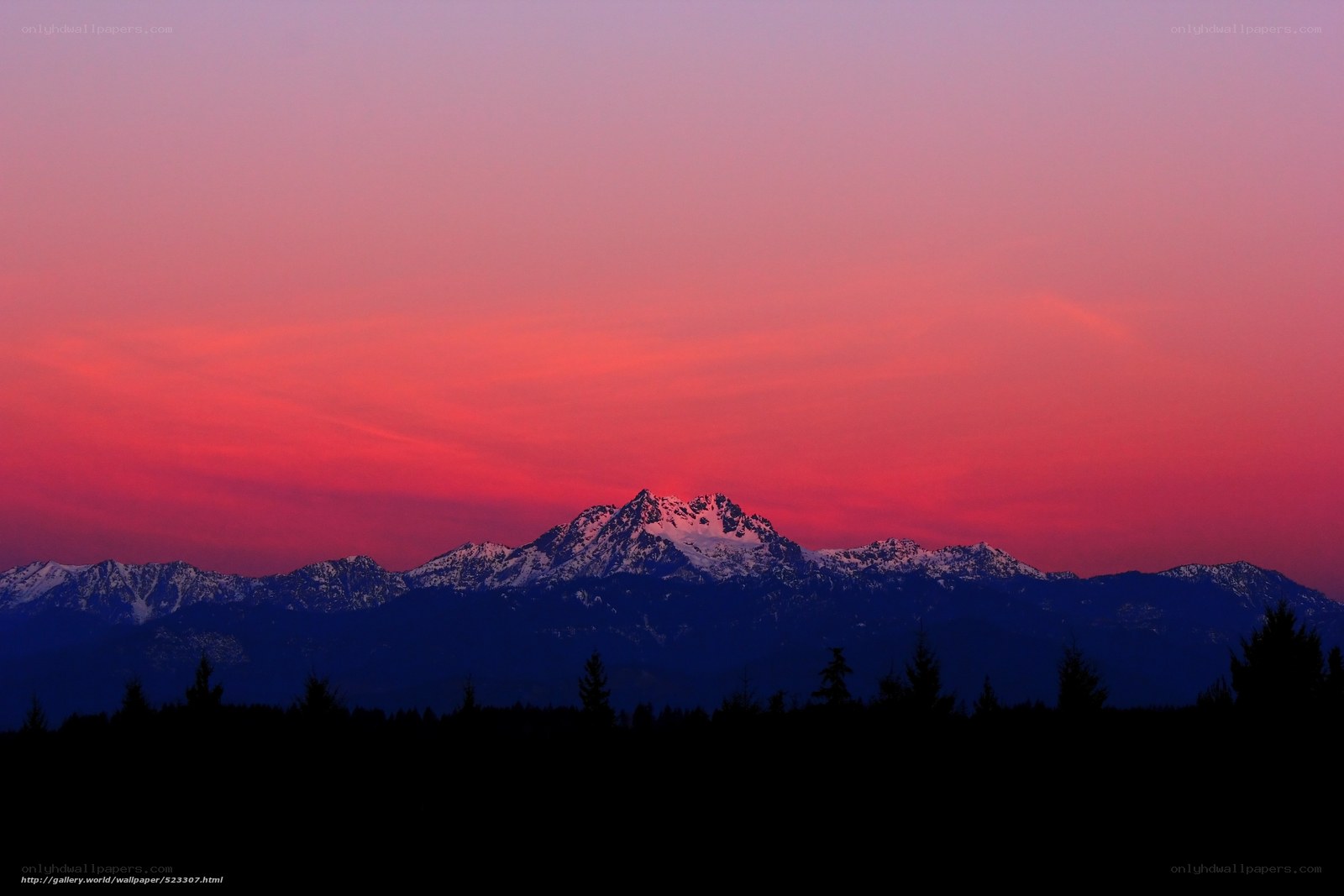 Red sunset over snow-capped mountains