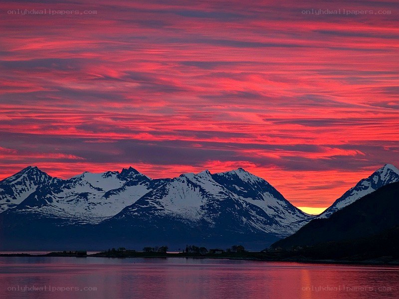 Red sunset over snowy mountains