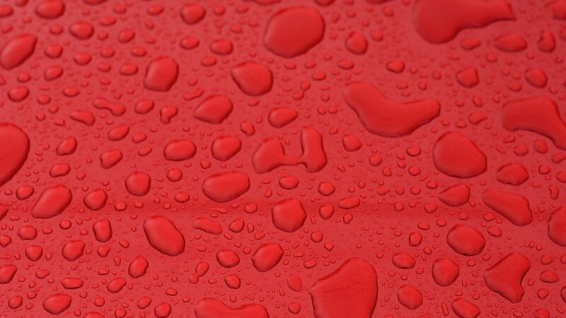 red surface with water droplets