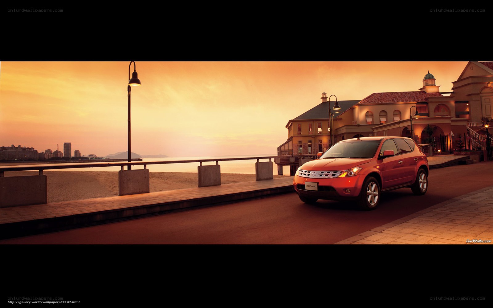 Red SUV at sunset by the sea
