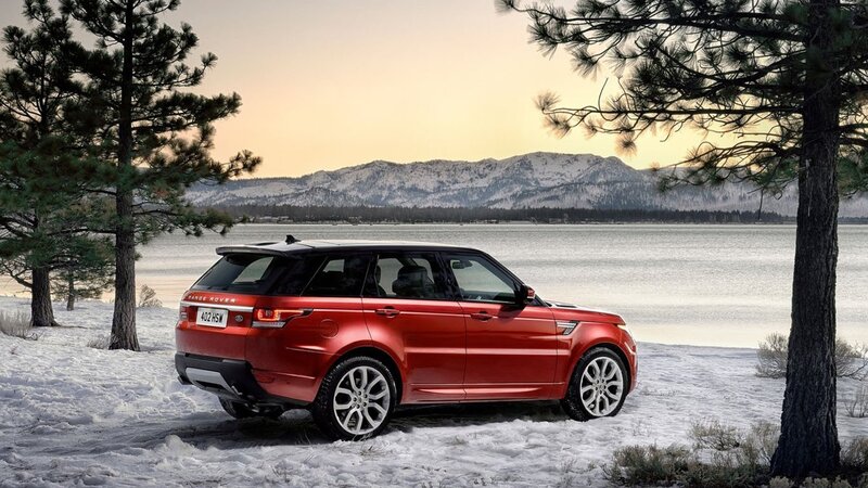 Red SUV by a snowy lake