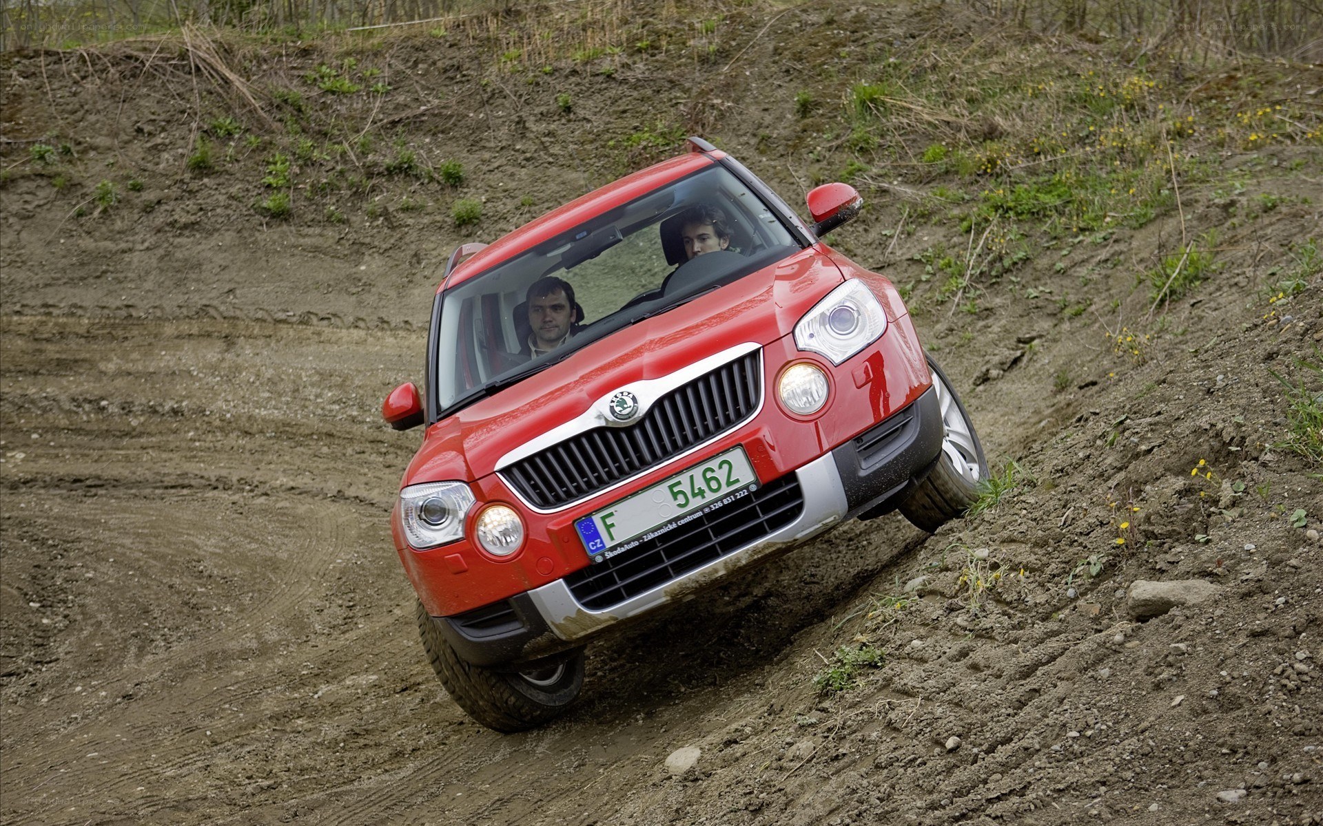 Red SUV climbing a dirt hill