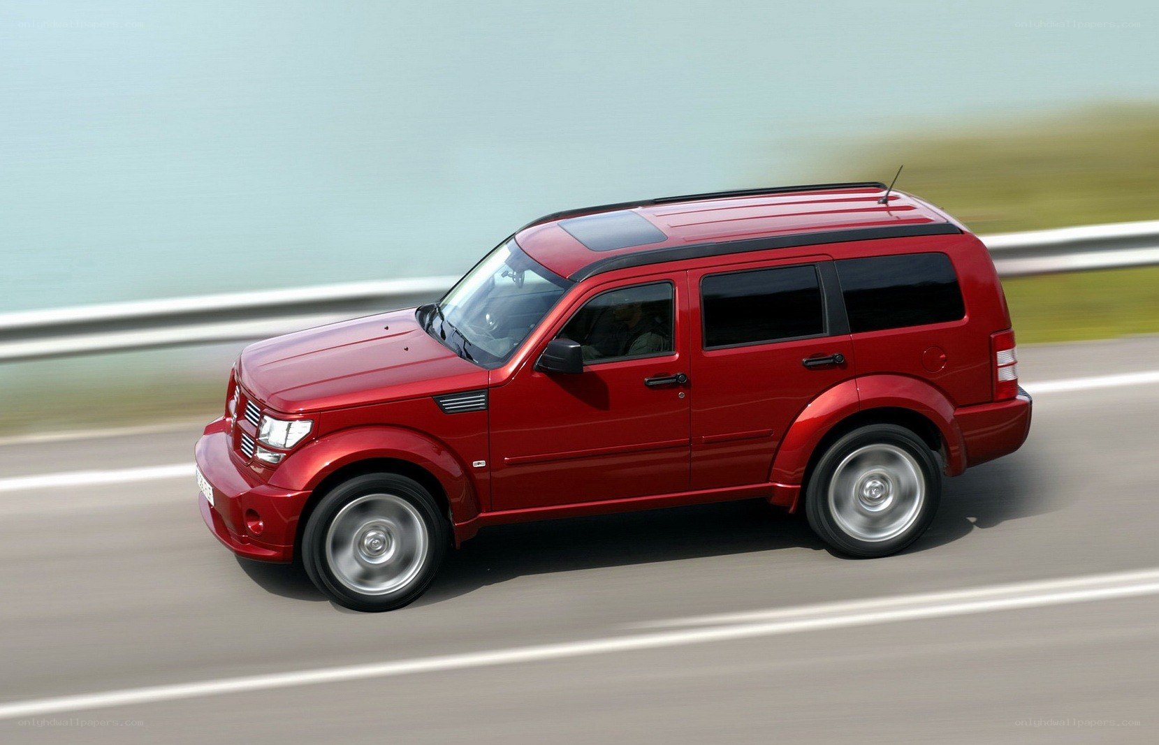 Red SUV driving on a road