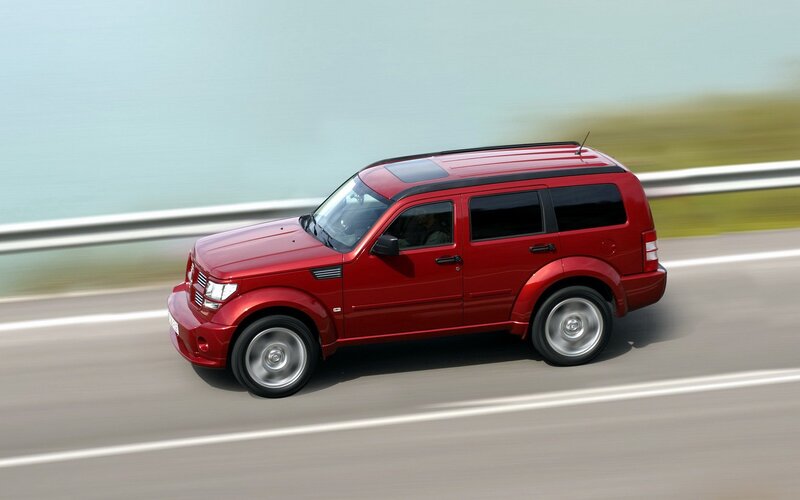 Red SUV driving on highway