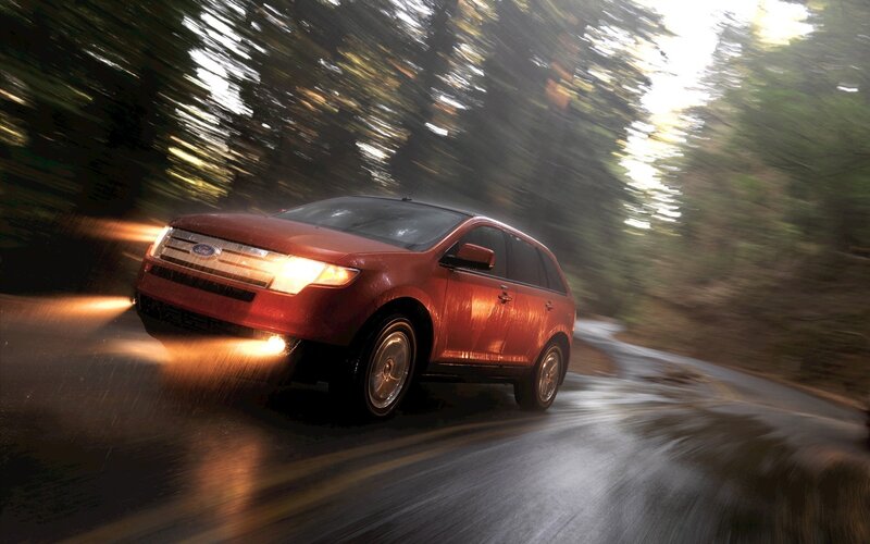 Red SUV driving on wet road