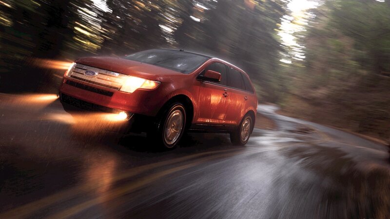 red suv driving on wet road