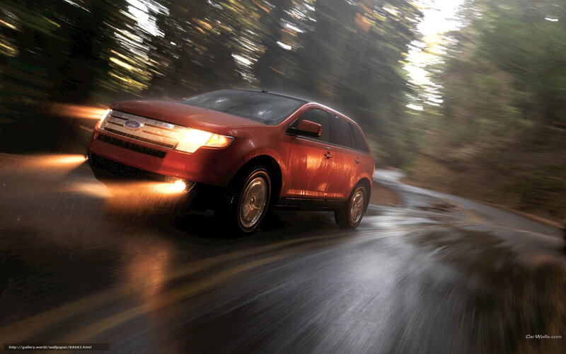 Red SUV driving on wet road