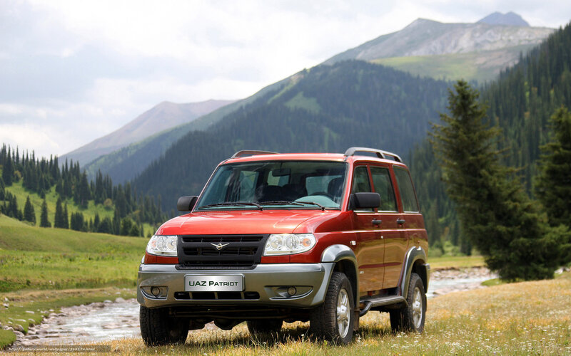 Red SUV in mountain valley