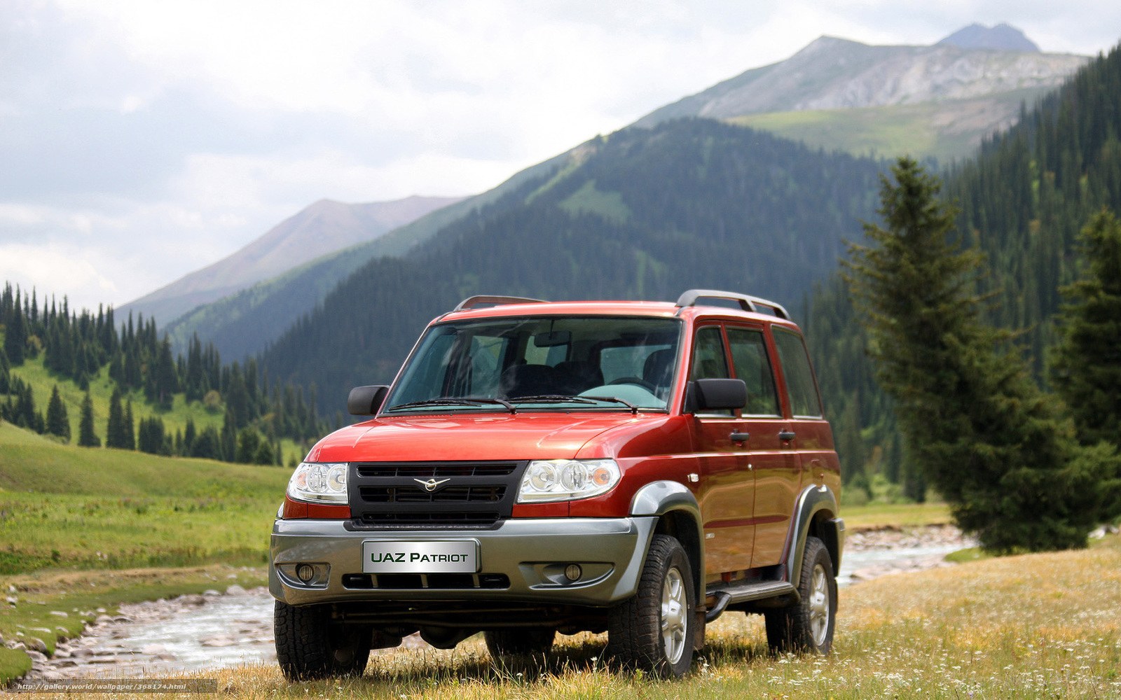 Red SUV in mountain valley