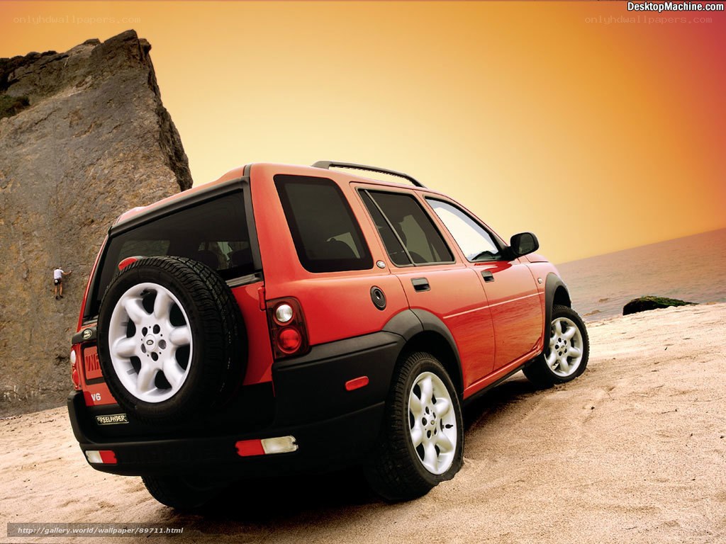 Red SUV on beach at sunset