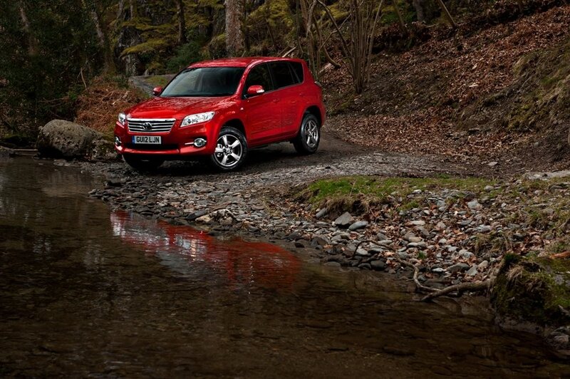 Red SUV on riverbank