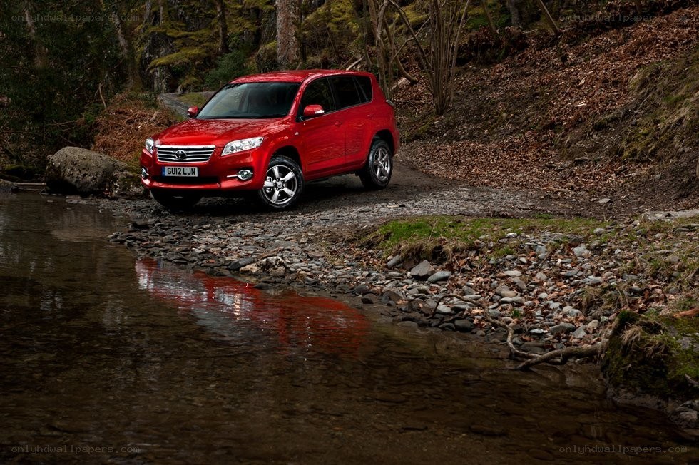 Red SUV on riverbank