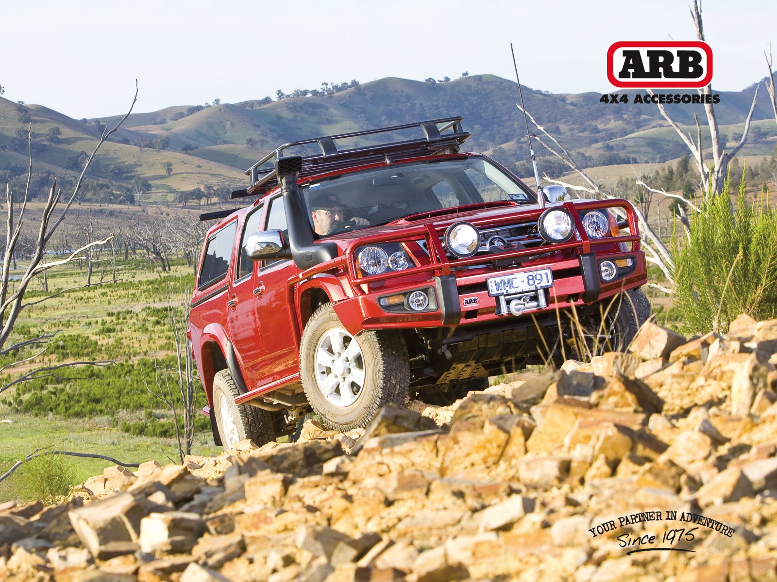 Red SUV on rocky terrain
