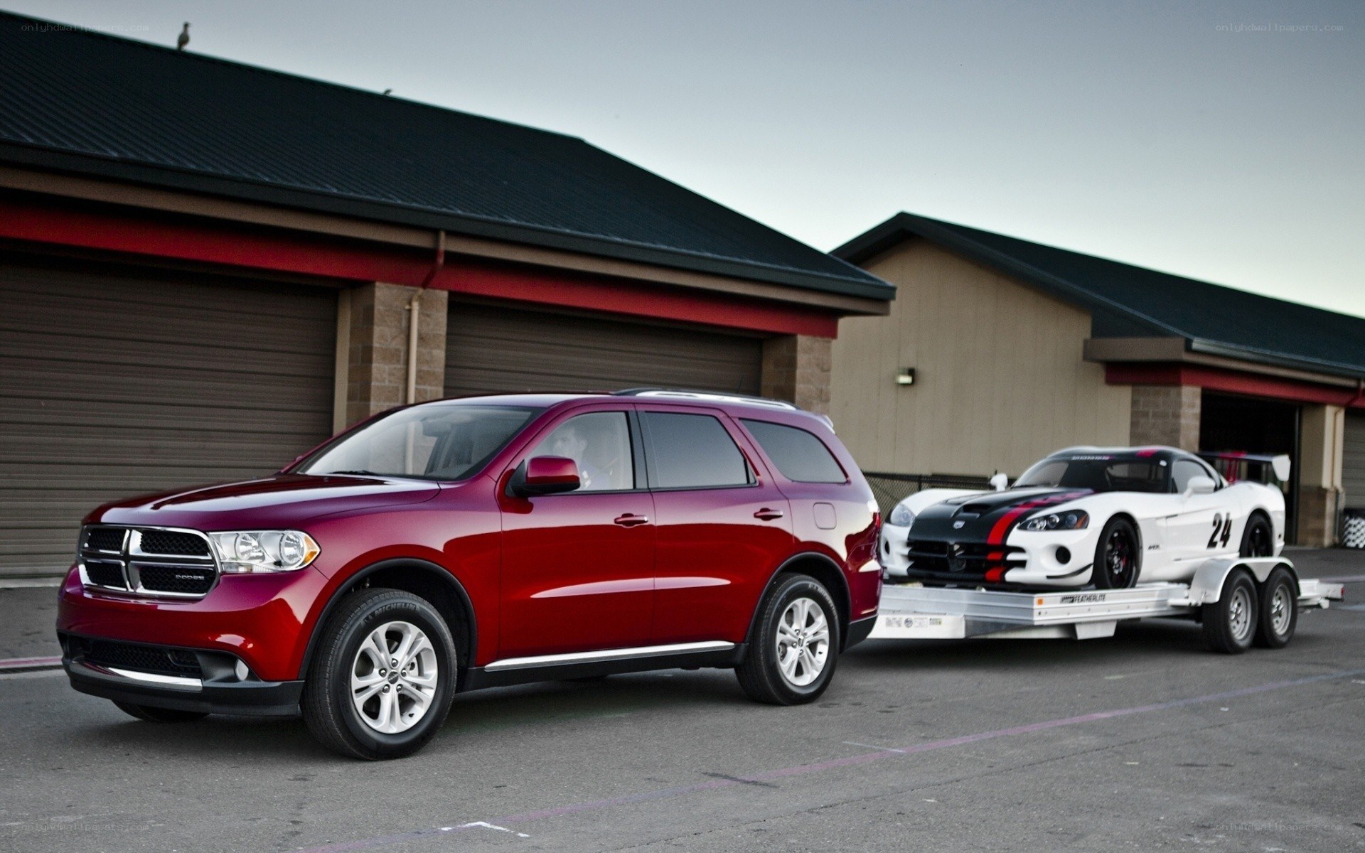Red SUV towing race car