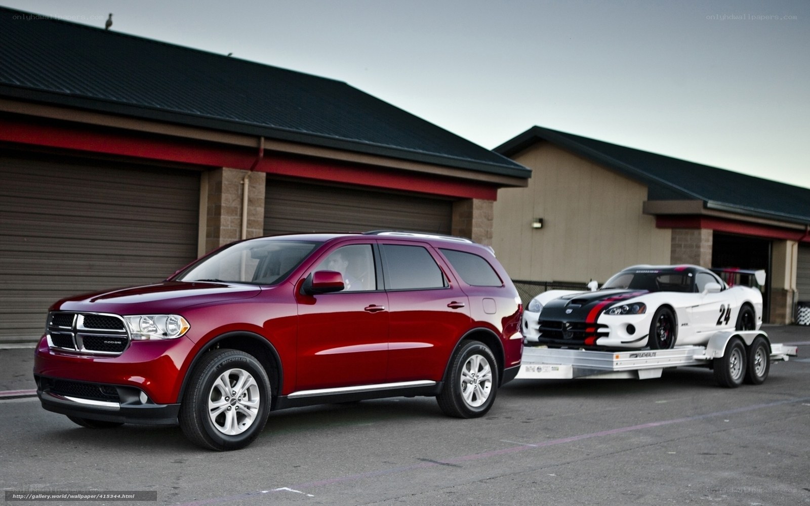 Red SUV towing race car