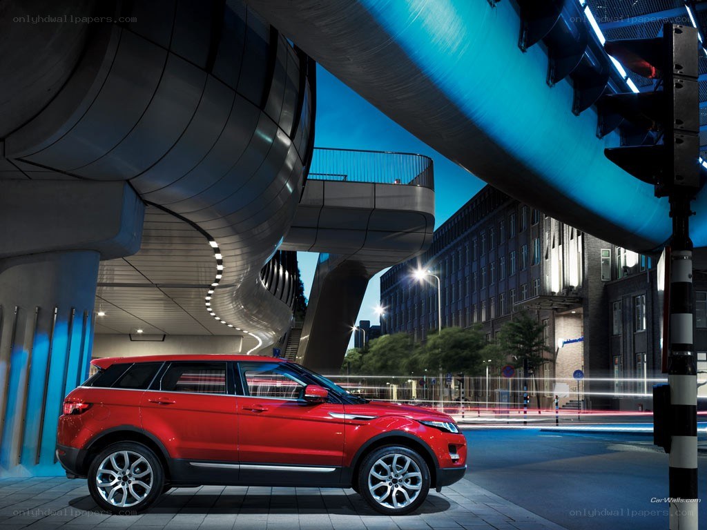 Red SUV under futuristic bridge