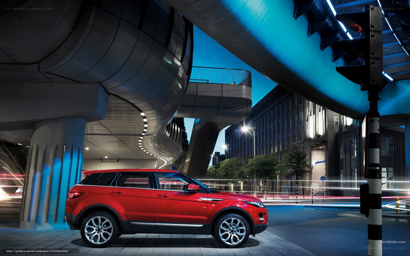 Red SUV under futuristic bridge