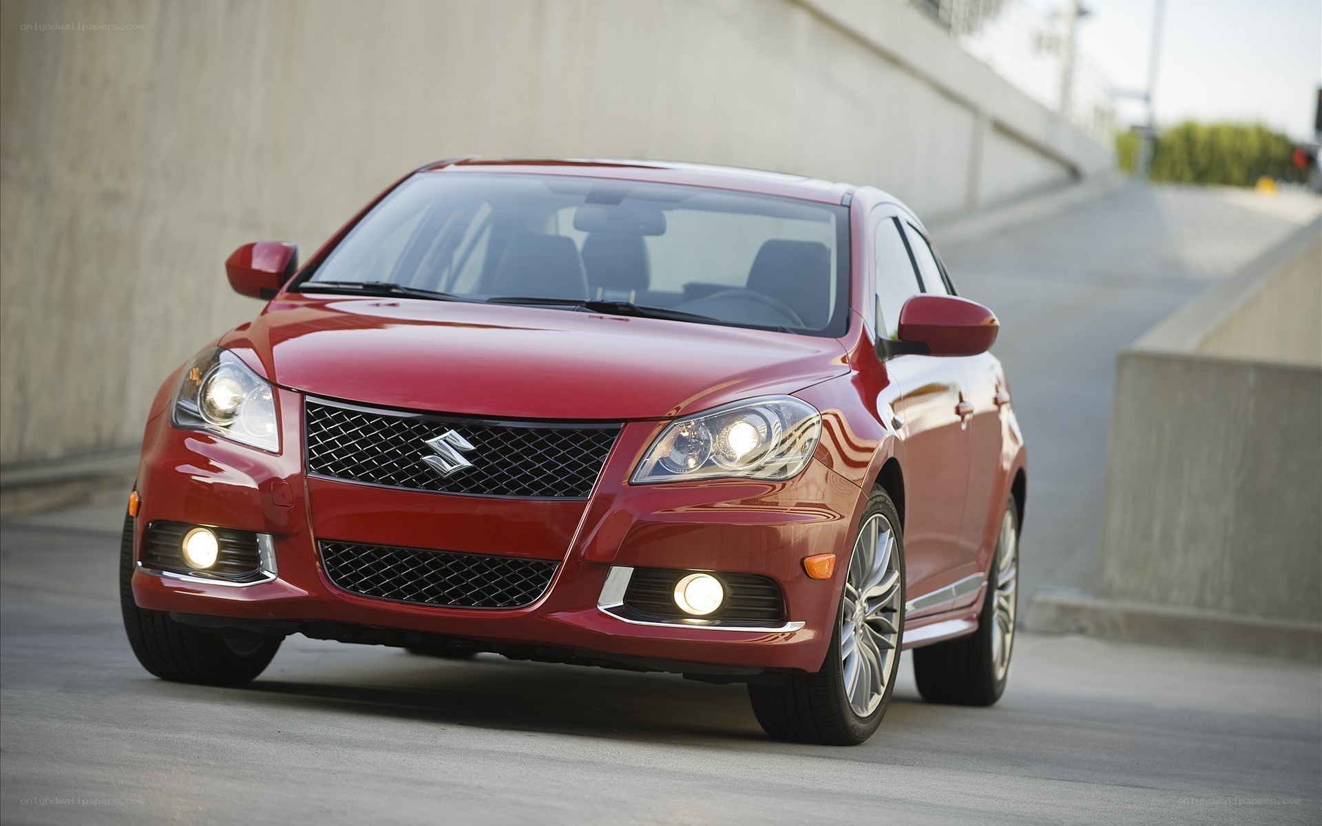 Red Suzuki sedan on road