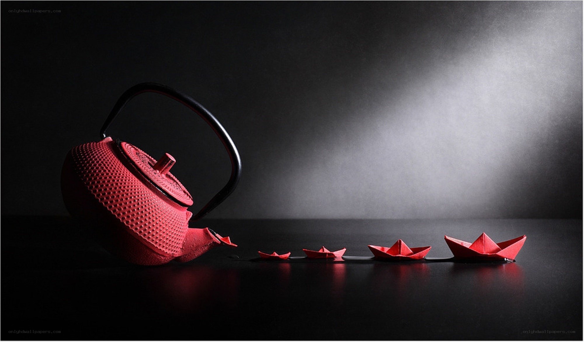 Red teapot with paper boats